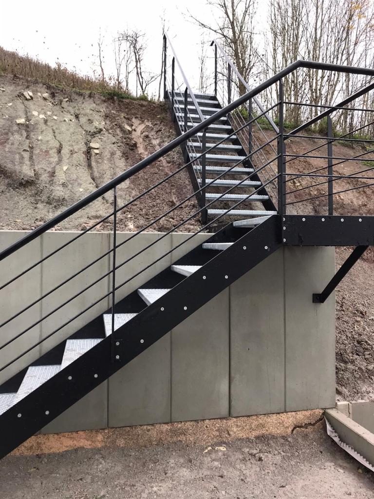 Escalier extérieur caillebotis le long d'un mur béton — Archimetal