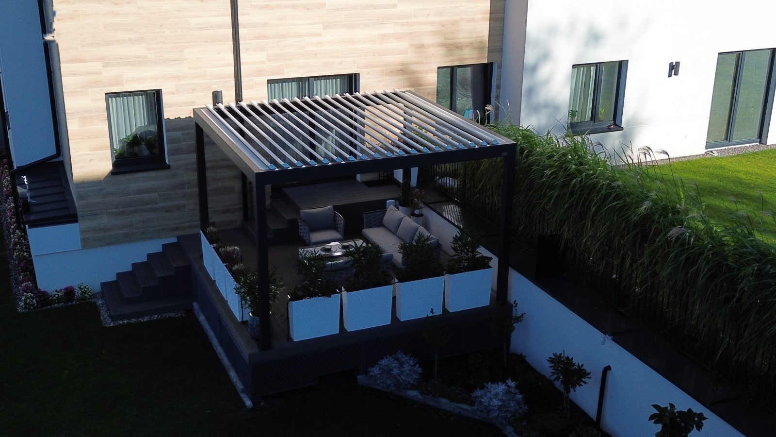 Pergola bioclimatique anthracite sur terrasse surélevée — Archimetal