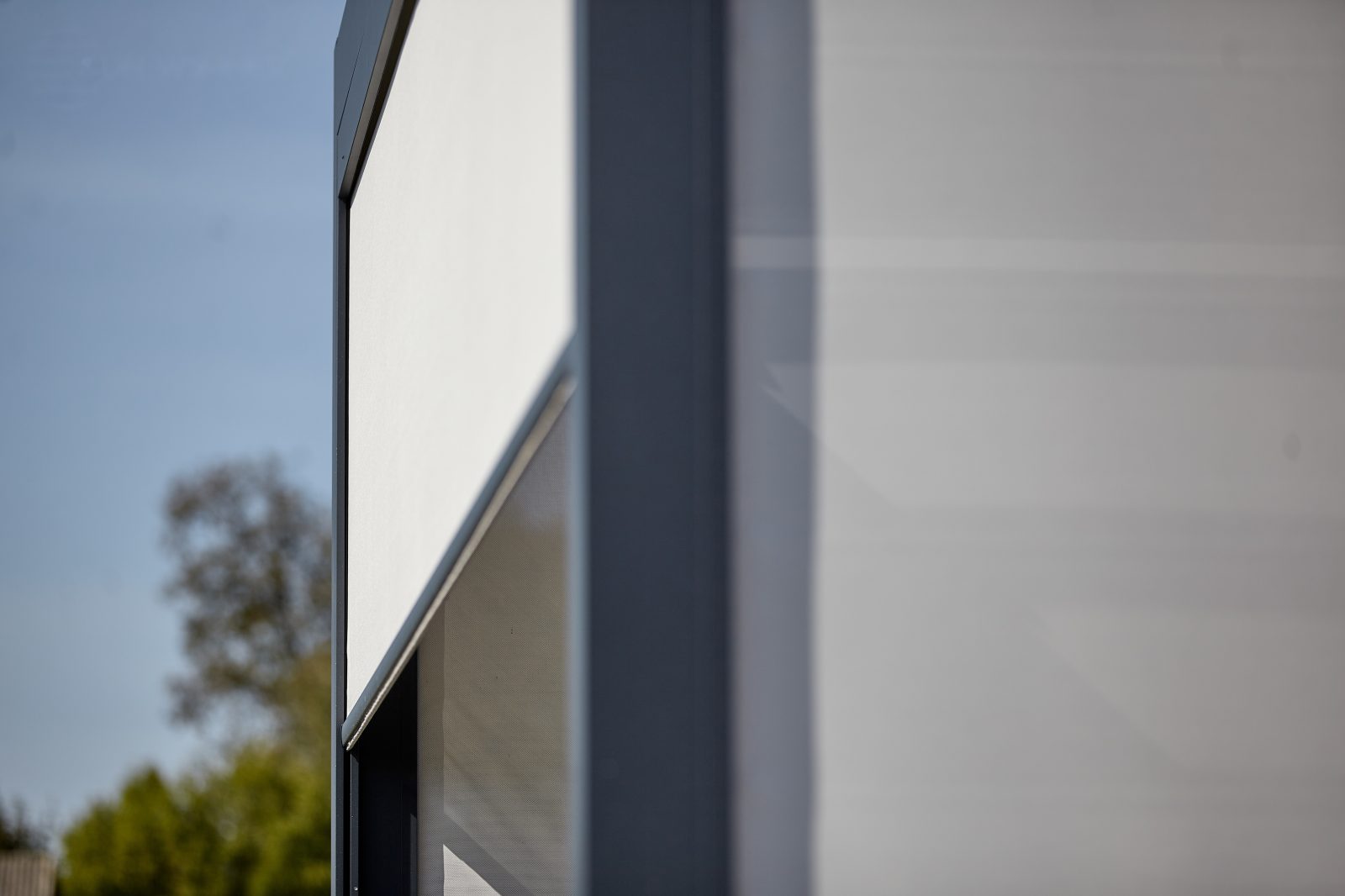 Détail d'un store zip vertical sur pergola — toile technique guidée sur rails — Archimetal